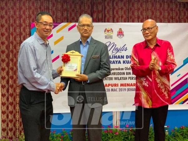 Salah seorang pengurus dewan menyerahkan kunci kepada Dr Shahruddin sambil diperhatikan Datuk Bandar Kuala Lumpur, Datuk Nor Hisham Ahmad Dahlan (kanan), hari ini.