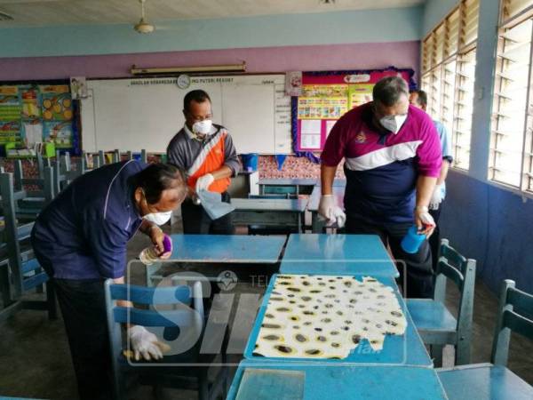 Aminolhuda membantu membersihkan dua buah kelas sebelum merasmikan program gotong-royong.