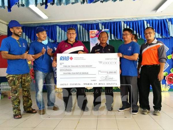 Aminolhuda menyampaikan sumbangan PPD kepada PIBG SK Tanjung Puteri Resort.