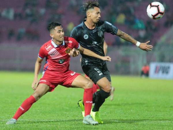 Pemain Kelantan, Nik Azli Nik Alias (kiri) bersaing dengan pemain import TFC II, Bruno Suzuki dalam pertemuan Liga Premier yang berkesudahan seri 1-1 di Kota Bharu, malam tadi.