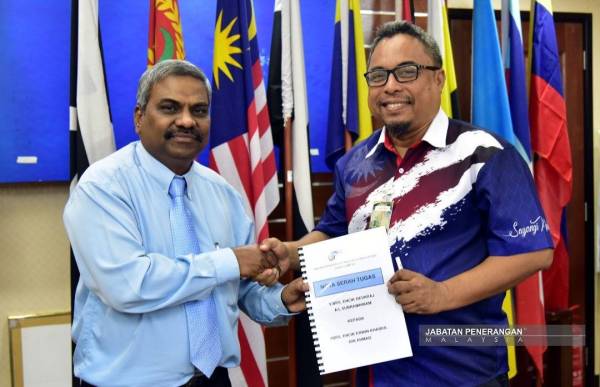 Erwin menerima nota serah tugas daripada Devaraj. 