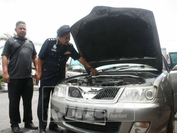 Abdullah (kanan) menunjukkan kereta jenis Proton Waja yang berjaya ditemui selepas menahan salah seorang suspek.