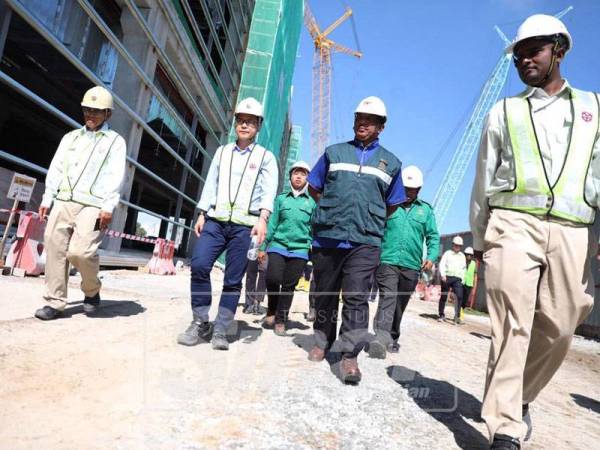 Zamzurin (dua, kanan) ketika mengadakan lawatan ke sebuah tapak pembinaan di Kawasan Perindustrian Bemban.