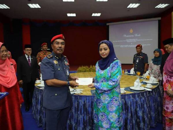 Raja Zarith menyampaikan cek sumbangan daripada Sultan Johor kepada Yahya. - FOTO: Royal Press Office