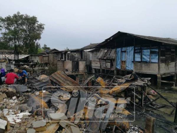 Penduduk melihat keadaan rumah mereka yang hangus terbakar.