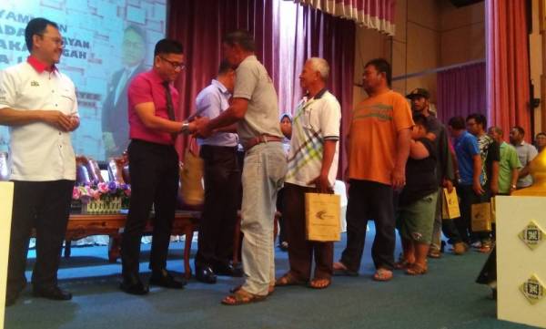 Norhizam ketika menyampaikan insentif sebanyak RM750 kepada setiap nelayan ketika majlis penyampaian insentif kepada nelayan Daerah Melaka Tengah di Dewan Seri Negeri, Ayer Keroh, di sini, hari ini.