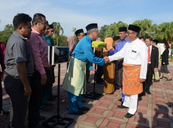 Adly (kanan) bersalaman dengan penjawat awam selepas Perhimpunan Bulanan Kerajaan Negeri di Dataran Seri Negeri, di Ayer Keroh, di sini, hari ini.