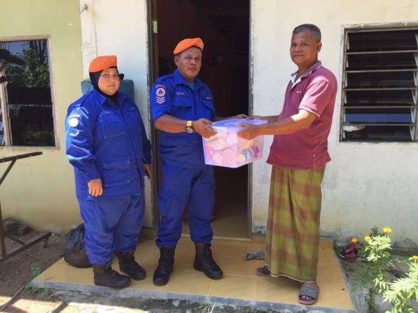 Anggota APM menyampaikan sumbangan berbentuk makanan kepada mangsa.