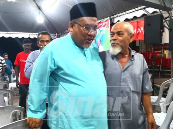 Zulkefly (kiri) bermesra dengan pengundi DUN Rantau di Bilik Gerakan di Taman Kelab Tuanku Mambau, malam tadi.