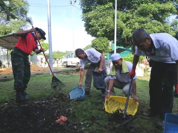 Mohamad Ghani (kiri) Program Gotong-royong amal PDRM bersama masyarakat di Tanah Perkuburan Islam Bandar Tun Hussein Onn, hari ini.