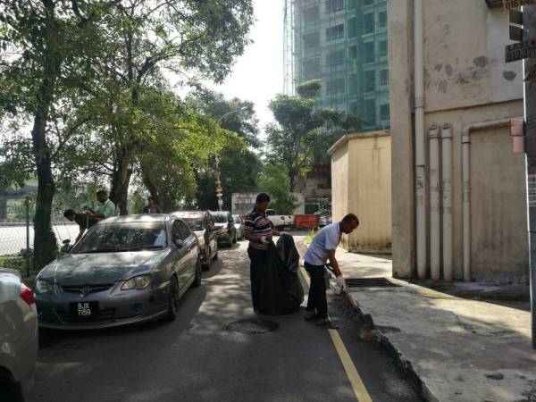 Penduduk bergotong-royong membersihkan kawasan persekitaran di Pangsapuri Dahlia tadi.