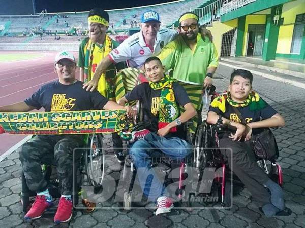 Abdul Malik (tengah) bergambar bersama rakannya diluar stadium.