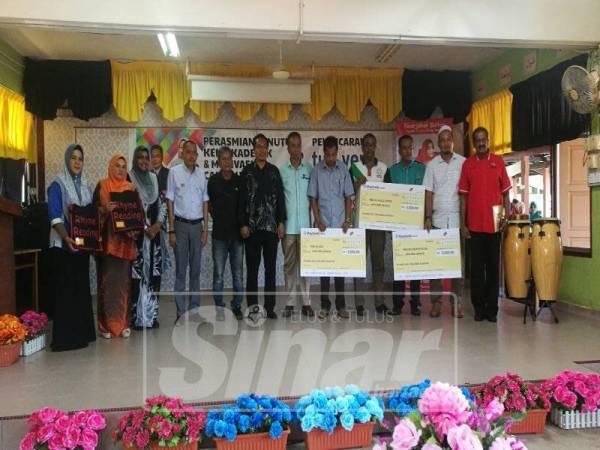Khairul (tujuh kanan) dan Mohd Razali (enam kanan) menyampaikan replika cek kepada tiga buah sekolah yang dipilih untuk tajaan tuisyen.