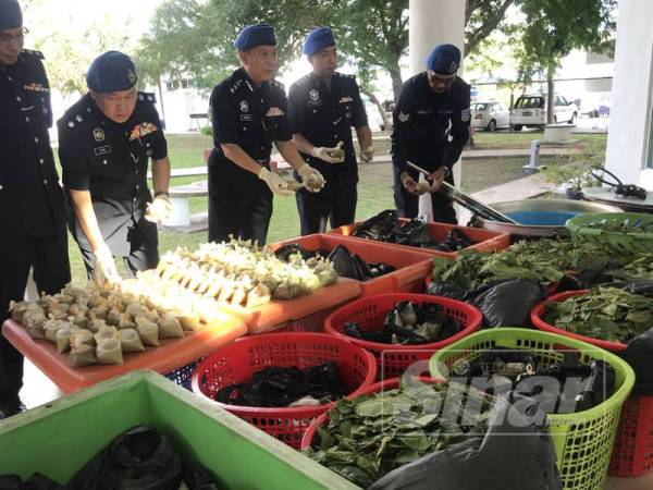 Rosman (tengah) menunjukkan barangan yang dirampas dari ketiga-tiga suspek dalam serbuan di sebuah rumah di Permatang Damar Laut pagi tadi.