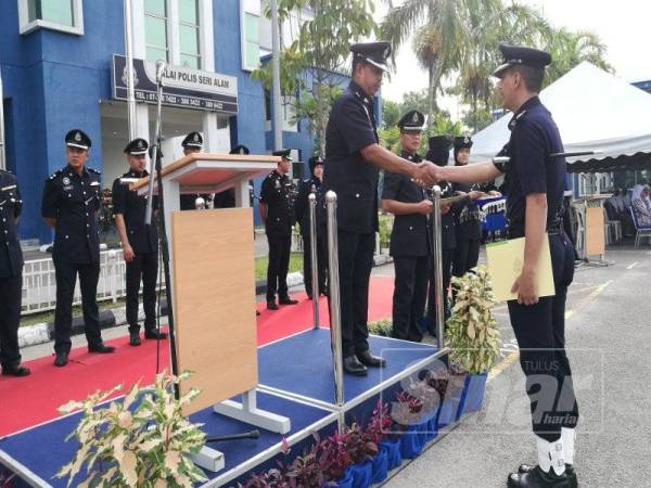 Ismail menyampaikan sijil penghargaan kepada pegawainya pada Perhimpunan Bulanan IPD Seri Alam, hari ini.