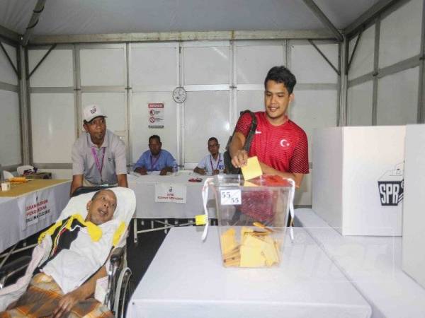 Azhari tunaikan tanggungjawabnya sebagai pengundi awal DUN Rantau, hari ini. - Foto:ADAM AMIR HAMZAH