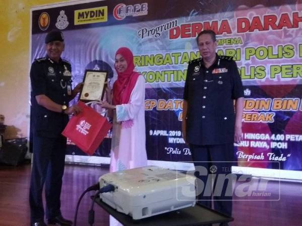 Razarudin menerima sijil penghargaan daripada Irni selepas menyempurnakan perasmian program tersebut di Pasar raya Besar Mydin Meru Raya, di sini, hari ini.