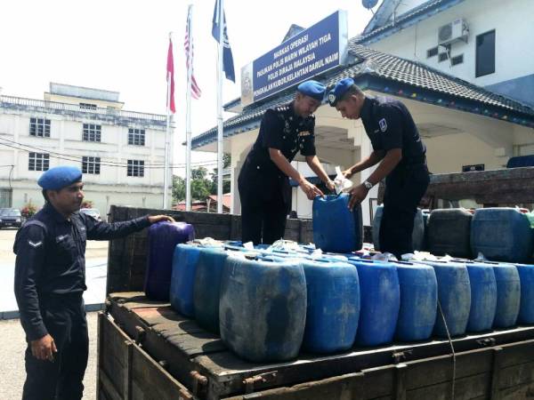 Mohd Rudzuan (tengah) bersama anggotanya memeriksa diesel yang dirampas si Markas PPM Pengkalan Kubor.