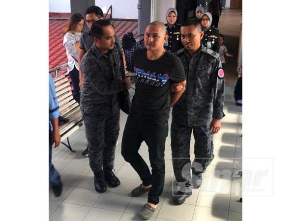 Mohd Asyraf (tengah) dikawal anggota Imigresen keluar dari mahkamah selepas hukuman diputuskan, hari ini.