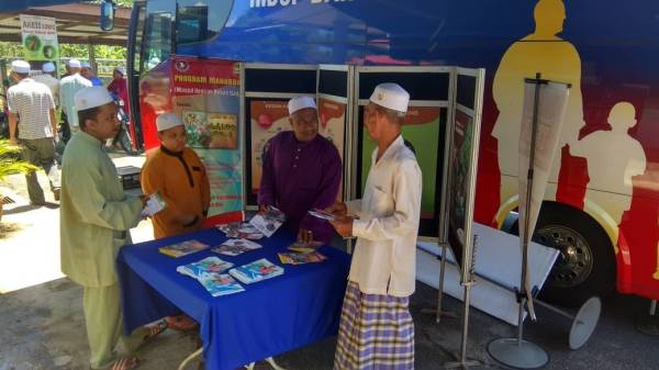 Jemaah masjid mendapatkan informasi mengenai bahaya dadah daripada penganjur dalam program Mahabah di Masjid Simpang Empat Sedaka.