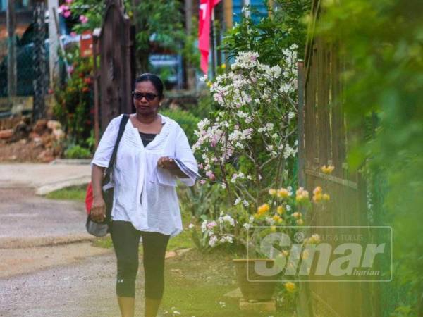 Malar berjalan kaki berkempen sambil membawa manifestonya.