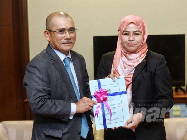 Bekas Pengerusi PAC, Datuk Seri Dr Ronald Kiandee bersama Pengerusi PAC baharu, Datuk Dr Noraini Ahmad memegang dokumen PAC. - Foto Sinar Harian Zahid Izzani