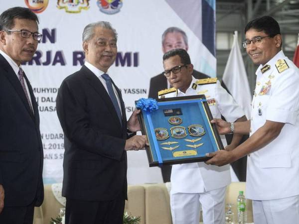 Menteri Dalam Negeri Tan Sri Muhyiddin Yassin (dua, kiri) menerima cenderahati daripada Ketua Pengarah Agensi Penguatkuasaan Maritim Malaysia (APMM) Laksamana (M) Datuk Seri Zulkifli Abu Bakar (kanan) sempena lawatan kerja rasmi beliau di Stesen Udara APMM Subang hari ini. - Foto Bernama