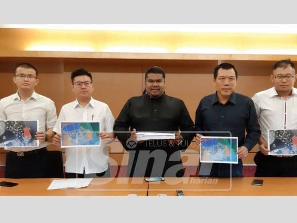 Arafat (tengah) bersama Sze Yee (dua dari kanan) dan Yee Chern (dua dari kiri) menunjukkan peta tanah yang telah dijual kepada syarikat milik bekas Adun Behrang pada sidang media di Wisma DAP, hari ini.