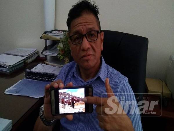 Norhizam menunjukkan sebuah projek perumahan di negeri ini yang didakwa menggunakan pasir laut yang dikorek dari kawasan Pantai Puteri.