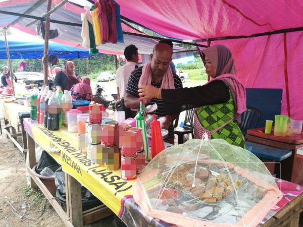 Mohd Nazri dan isterinya sedang memproses ais kacang.