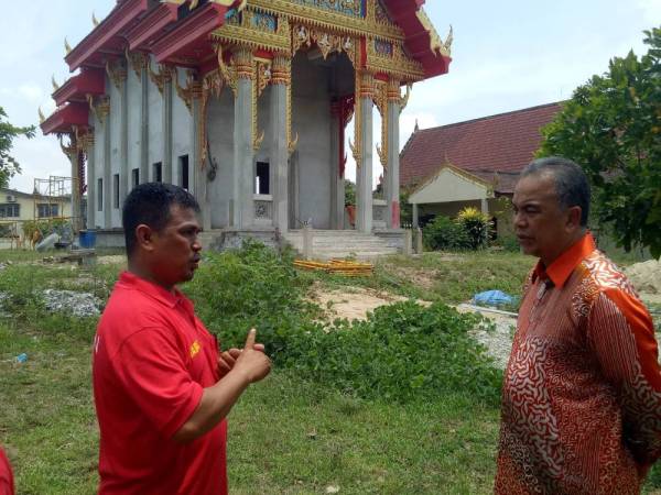 Setiausaha DAP Bahagian Padang Terap, Mejar (B) Kim Fong a/l Kiat (kiri) menerangkan tentang pembinaan Wat Phikulthararam kepada Amiruddin, semalam. 