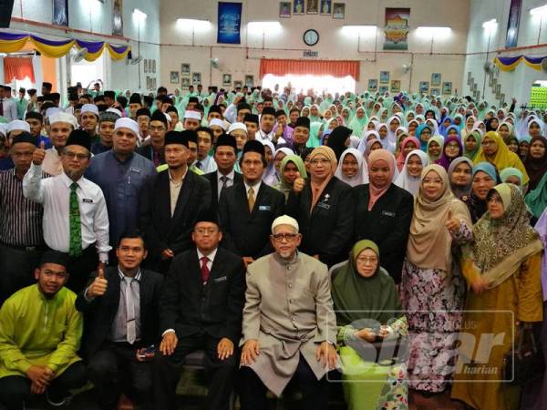Abdul Hadi (tengah) merakam gambar bersama pelajar dan guru sempena majlis Bicara Tokoh Alumni di SMAASZA, hari ini.