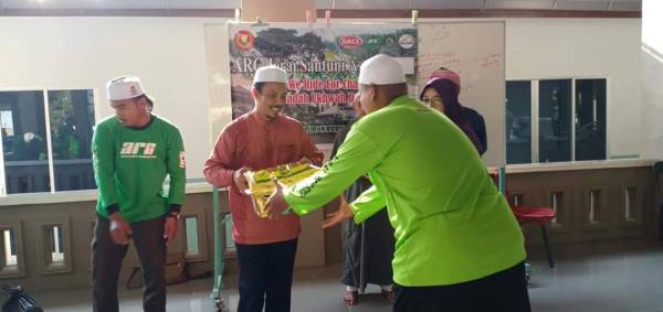Sabri (dua dari kiri) menyampaikan sumbangan kepada asnaf di Masjid Putra Al Haj, Yan hari ini.