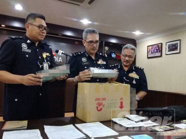 Mohamad menunjukkan rokok yang dirampas. 