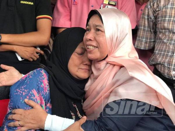 Siti Maznah tidak dapat menahan sebak dipujuk oleh Zuraida (kanan) sebaik sahaja sidang media berakhir, hari ini.