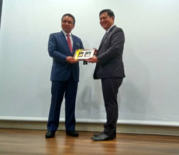 Adly (kiri) menerima cenderahati daripada Chee Hong ketika lawatan ke Infineon Technologies (M) Sdn Bhd di Batu Berendam, di sini, hari ini.