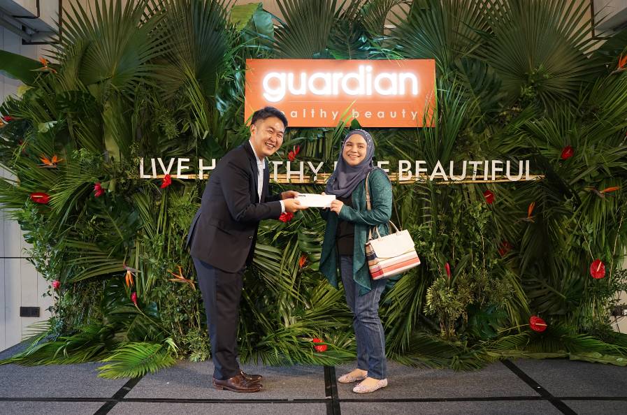 Pemenang bertuah, Afiza Kamarulzaman menerima hadiah cabutan nombor bertuah daripada Dy Cho pada Pameran 'Let's Go Natural' di Petaling Jaya, baru-baru ini.