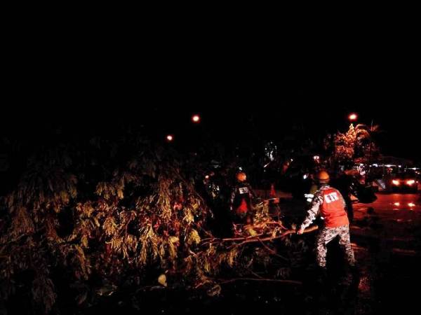 Anggota Skuad Pantas MDKL mengalihkan pokok tumbang di sekitar Banting awal pagi tadi.