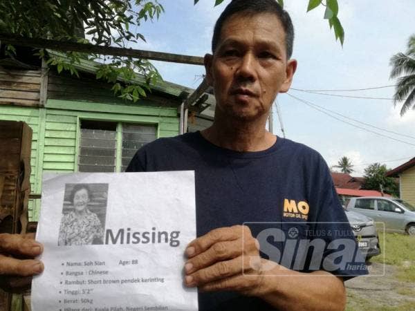 Beng Hua menunjukkan poster pencarian ibunya. 