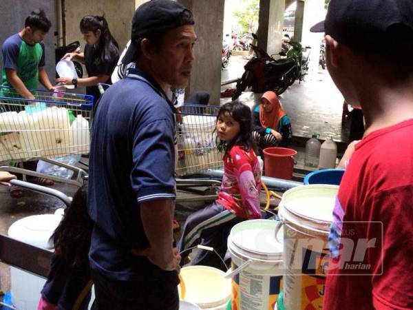 Sebahagian penduduk Blok E Projek Perumahan Rakyat (PPR) Lembah Subang menadah air dalam bekas untuk diangkut naik ke rumah.