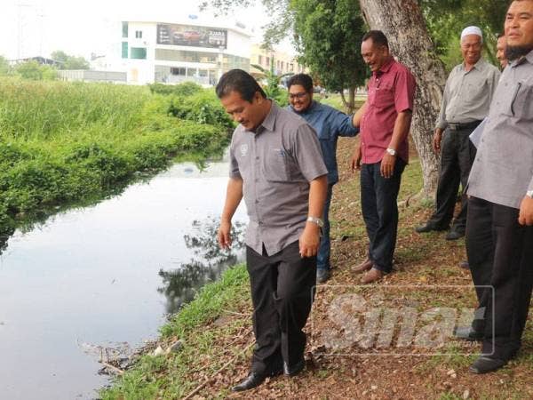 Azman sedang memantau keadaan saliran air berdekatan sawah yang terjejas.