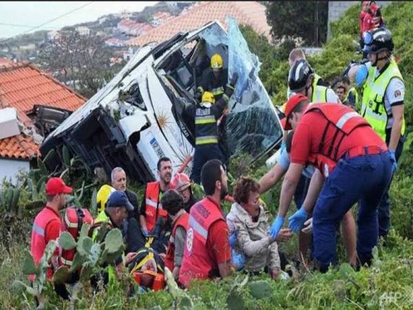 Antara mangsa yang terselamat dibantu anggota penyelamat. - Foto AFP