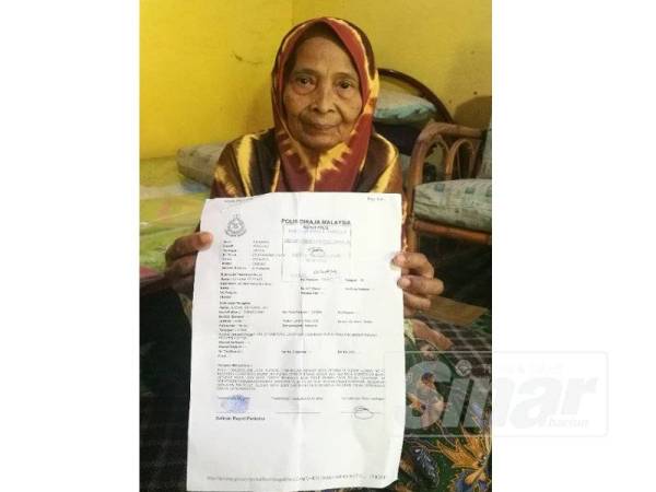 Aminah menunjukkan laporan polis dibuatnya.
