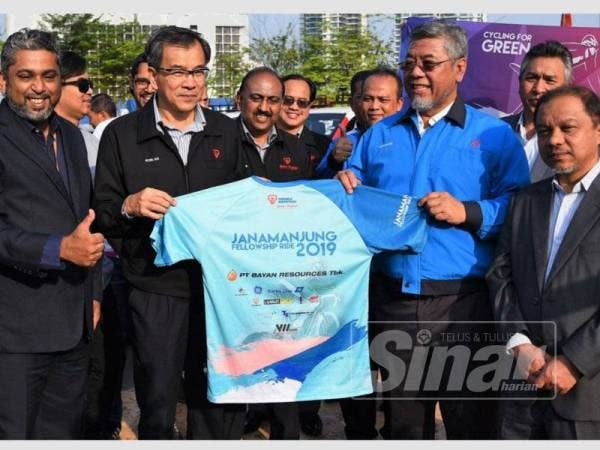 Roslan (dua dari kiri) menyerahkan jersi TNB JMFR 2019 kepada Shamsul (du dari kanan) pada Majlis Prapelancaran JMFR 2019 di Dataran Vibrant, Ibu Pejabat TNB, Bangsar semalam.