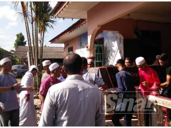 Jenazah Rogayah dibawa keluar dari rumah untuk dikebumikan di Tanah Perkuburan Atas Tol.