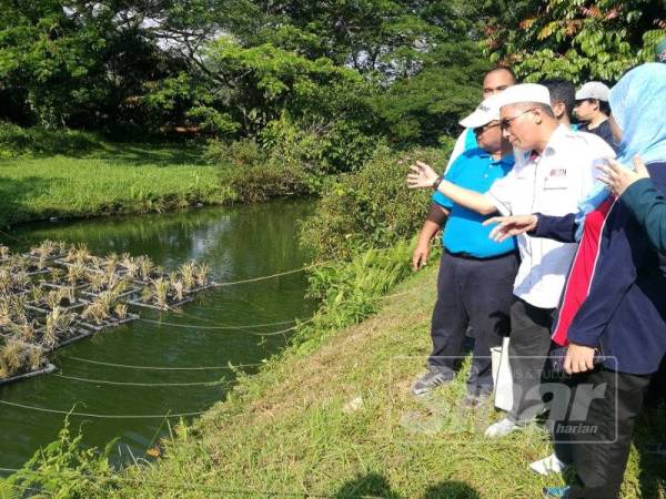Azmi menerangkan cara 'floating wetland' berfungsi kepada tetamu yang hadir bagi menyaksikan projek tersebut.
