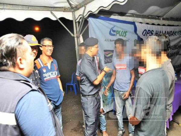 Mohd Izzarie (tengah) menjalankan pemeriksaan susulan terhadap lima kelindan dan pemandu kenderaan berat dikenal pasti positif dadah dalam operasi bersepadu di Hentian R&R Gunong Semanggol arah selatan, malam tadi.