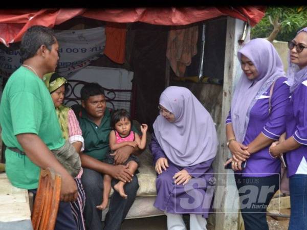 Rusnah (tiga,kanan) ketika melawat Abdul Rahman bersama isteri dan anaknya yang tinggal di pondok berhampiran rumah ibunya yang lumpuh di Kampung Paya Rumput Hilir, Tangga Batu.