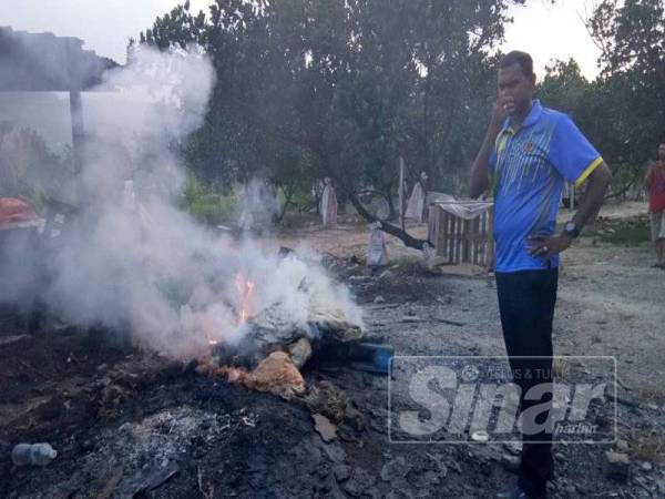 Yogeswaran menutup hidung kerana tidak tahan bau busuk akibat perbuatan membakar bangkai ayam dalam sebuah kebun di Pajam, semalam.