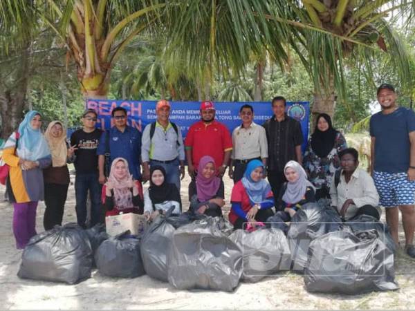 Mohd Ridzwan (tengah) bergambar bersama rombongan lawatan selepas acara gotong-royong membersihkan Pulau Bidan, semalam.